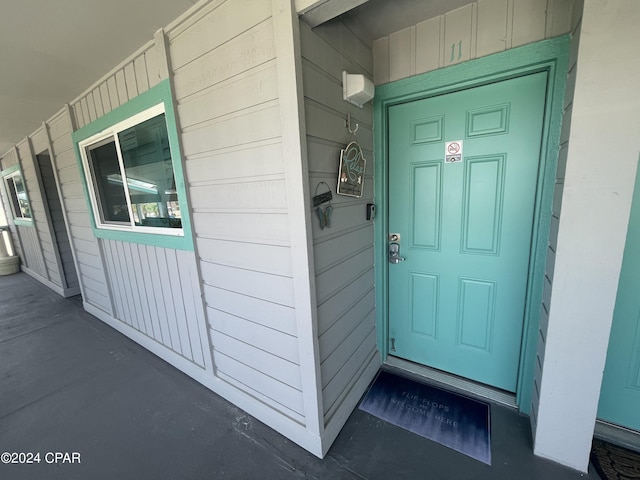 view of exterior entry featuring covered porch