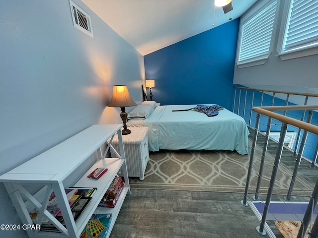 bedroom featuring ceiling fan, multiple windows, lofted ceiling, and hardwood / wood-style floors