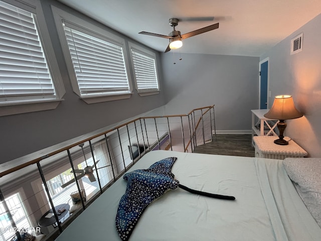 bedroom with visible vents, ceiling fan, baseboards, and wood finished floors
