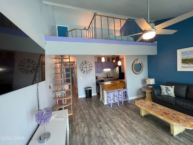 living room with ceiling fan, sink, a high ceiling, and dark hardwood / wood-style flooring