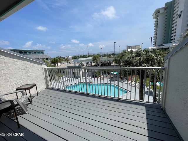 wooden terrace with a community pool