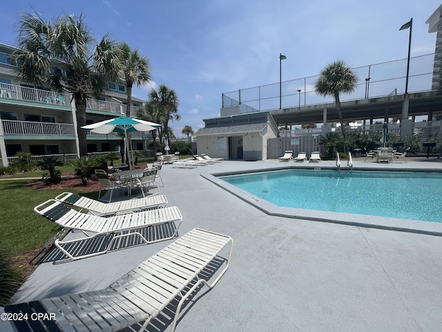 pool with a patio area and fence