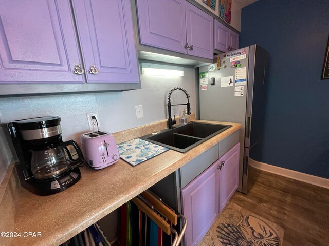 kitchen with sink, stainless steel fridge, and wood-type flooring