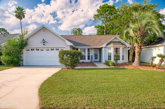 ranch-style house featuring a front yard, driveway, and an attached garage