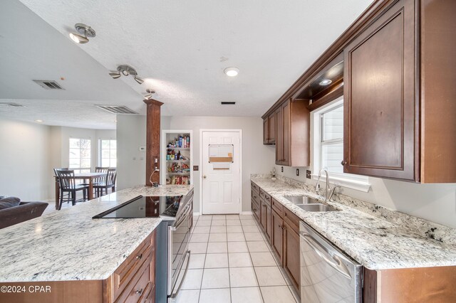 kitchen featuring dishwasher, light stone countertops, light tile patterned floors, sink, and range with electric stovetop