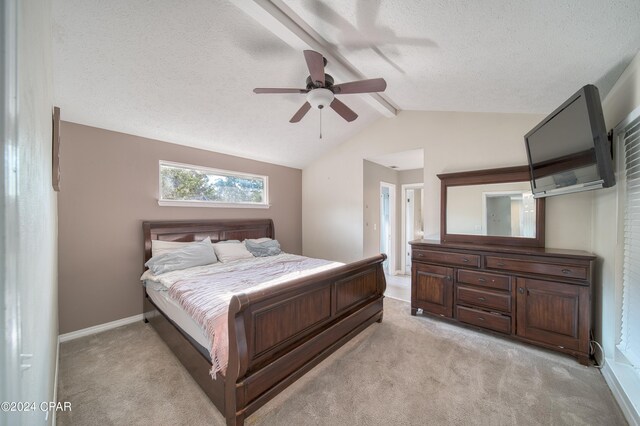 carpeted bedroom featuring ceiling fan, lofted ceiling with beams, and a textured ceiling