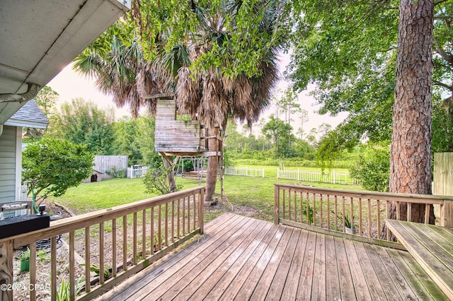 wooden terrace featuring a fenced backyard and a lawn
