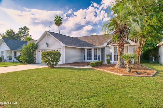 ranch-style home featuring cooling unit, a garage, and a front yard