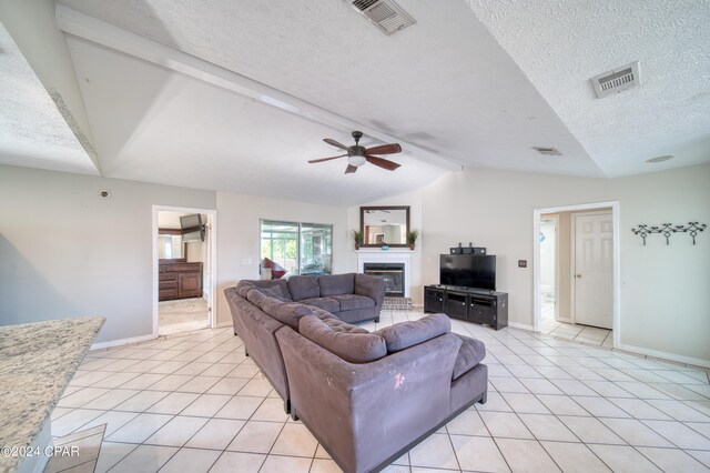 living room featuring light tile patterned floors, vaulted ceiling with beams, ceiling fan, and a textured ceiling