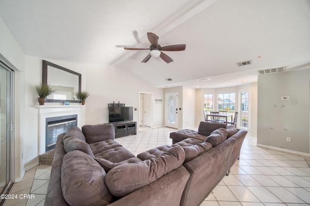 living area with a glass covered fireplace, visible vents, and light tile patterned floors