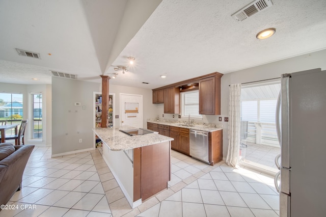 kitchen featuring open floor plan, appliances with stainless steel finishes, visible vents, and brown cabinets