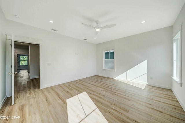 empty room with ceiling fan and light hardwood / wood-style flooring