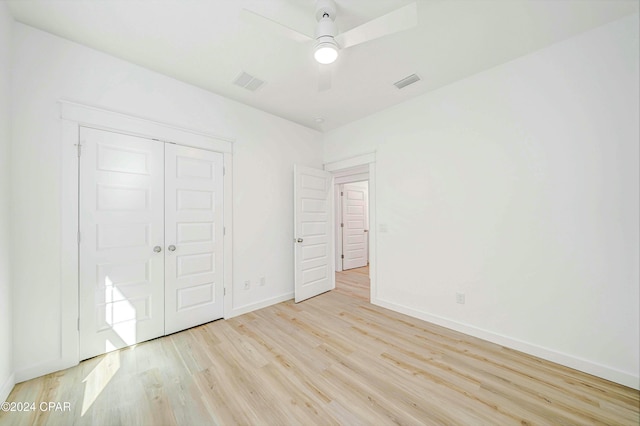 unfurnished bedroom featuring ceiling fan, light wood-type flooring, and a closet