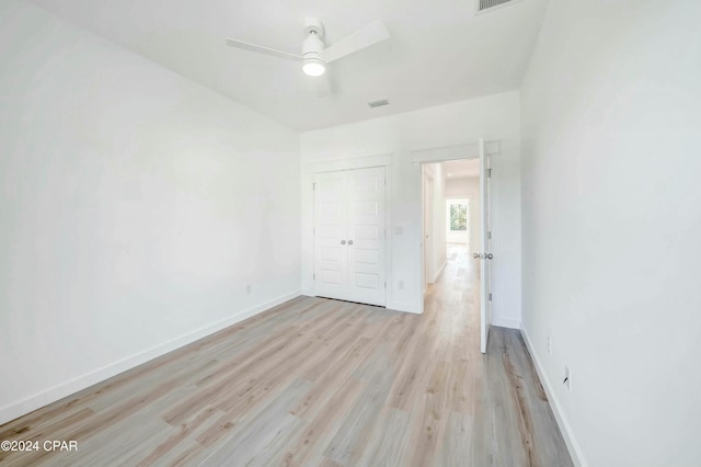 unfurnished bedroom featuring light hardwood / wood-style floors, a closet, and ceiling fan