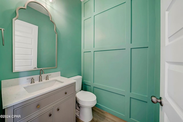 bathroom featuring hardwood / wood-style flooring, vanity, and toilet