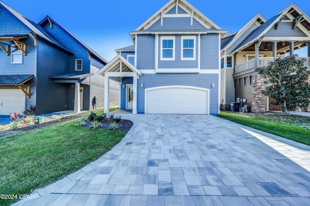 view of front of property featuring a garage, a front lawn, and a balcony