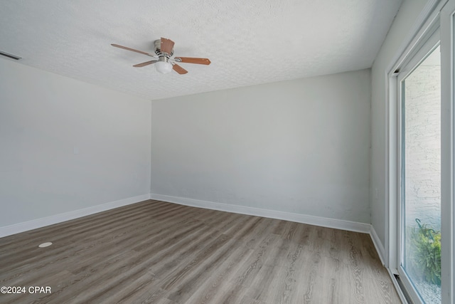 empty room featuring a textured ceiling, hardwood / wood-style floors, and ceiling fan