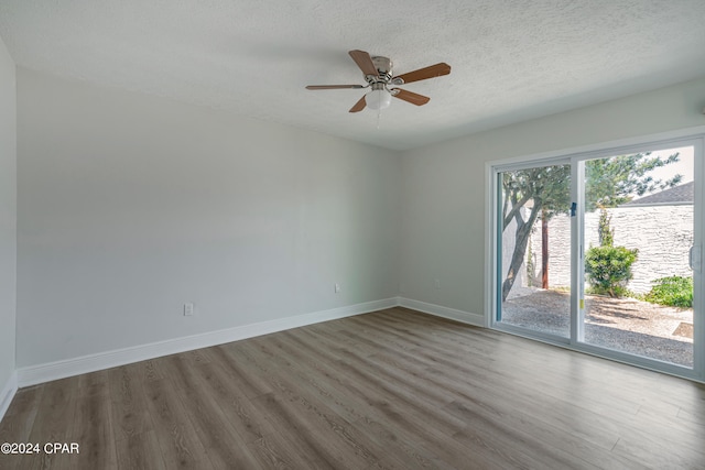 empty room with ceiling fan, wood-type flooring, and a wealth of natural light