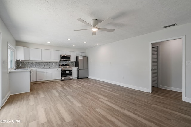 interior space with ceiling fan, sink, a textured ceiling, and light hardwood / wood-style floors