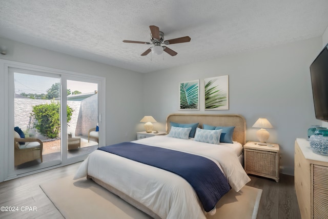 bedroom with ceiling fan, access to outside, a textured ceiling, and hardwood / wood-style flooring