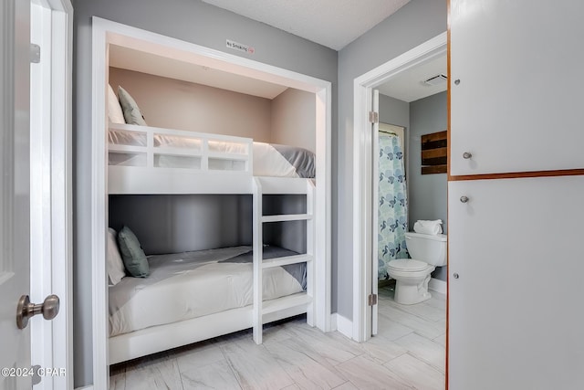 bedroom featuring marble finish floor, baseboards, visible vents, and connected bathroom