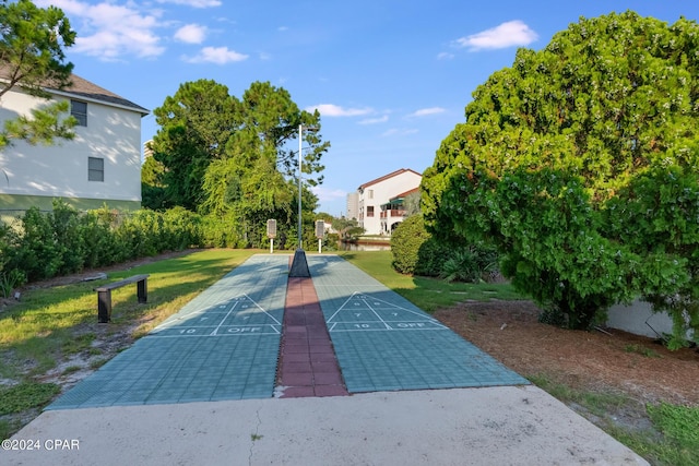 view of home's community with a yard and shuffleboard