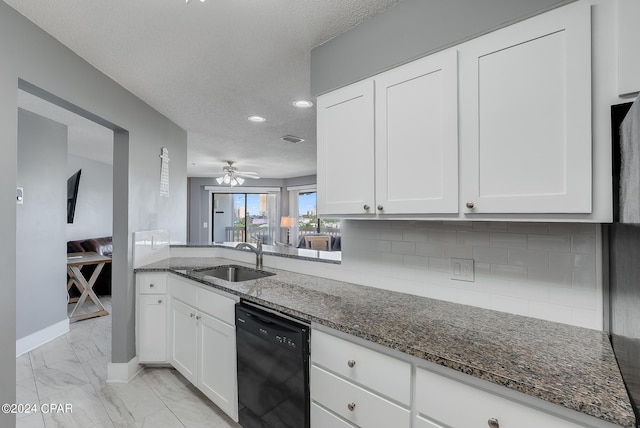 kitchen with marble finish floor, white cabinets, a sink, dark stone countertops, and dishwasher