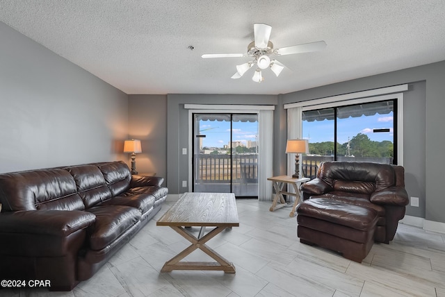 living area with a textured ceiling and a ceiling fan