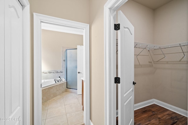 interior space featuring hardwood / wood-style floors and shower with separate bathtub