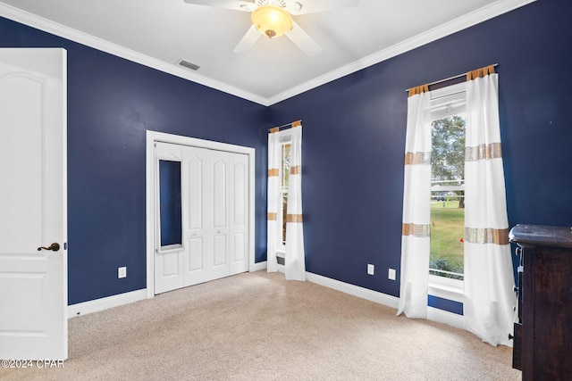 unfurnished bedroom featuring crown molding, light carpet, a closet, and ceiling fan