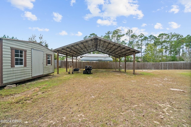 view of yard featuring a storage unit and a carport