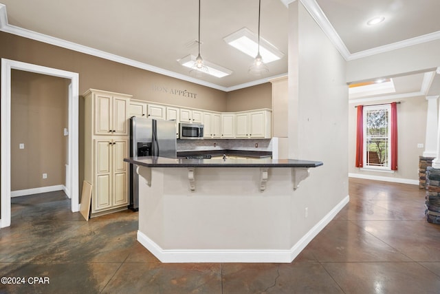 kitchen featuring a breakfast bar area, appliances with stainless steel finishes, cream cabinetry, and pendant lighting