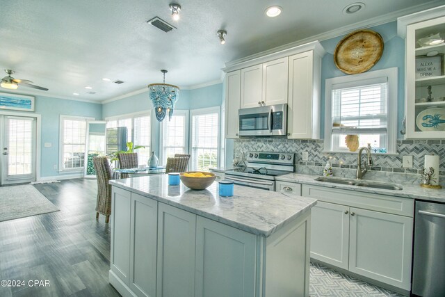 kitchen featuring backsplash, sink, stainless steel appliances, and a kitchen island