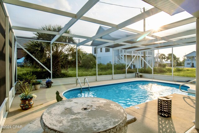 view of swimming pool featuring a patio area and a lanai