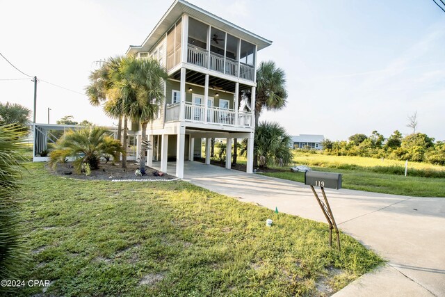 view of front of home featuring a balcony, a front yard, and a carport