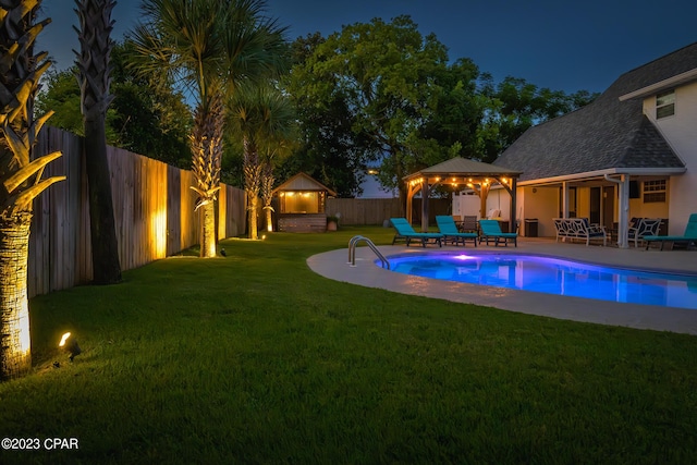 pool at twilight featuring a patio area, a gazebo, and a yard