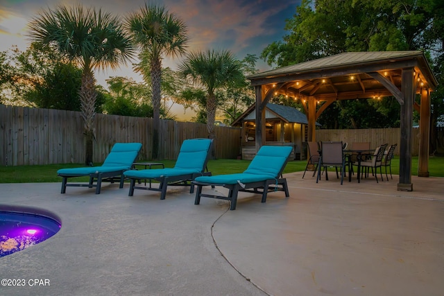 patio terrace at dusk with a gazebo and an outdoor structure