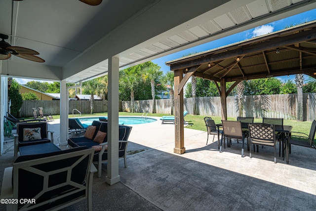 view of patio / terrace with a fenced in pool, a gazebo, and ceiling fan