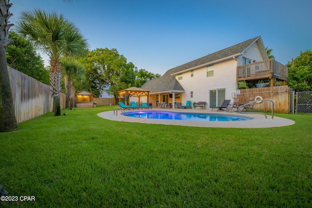 view of pool featuring a wooden deck, a gazebo, a yard, and a patio