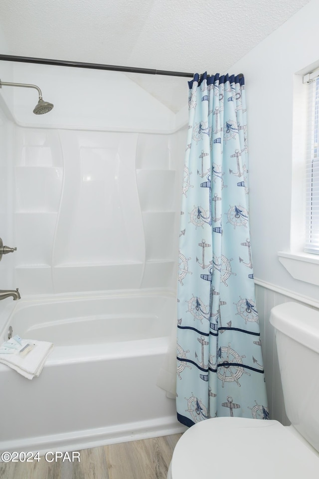 bathroom featuring toilet, plenty of natural light, shower / tub combo with curtain, and hardwood / wood-style flooring