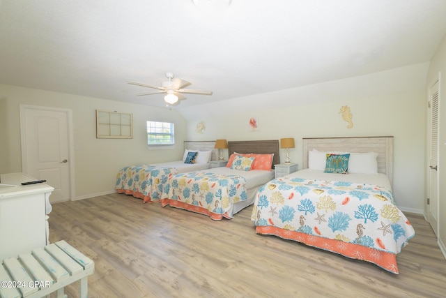 bedroom featuring ceiling fan, light hardwood / wood-style floors, and vaulted ceiling