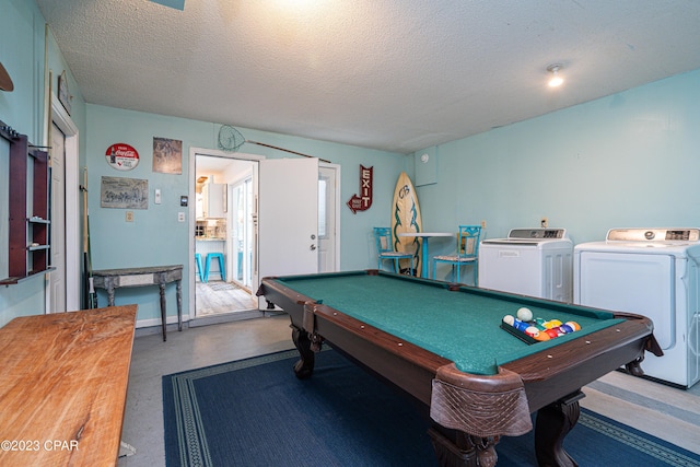 game room with a textured ceiling, pool table, and washing machine and clothes dryer