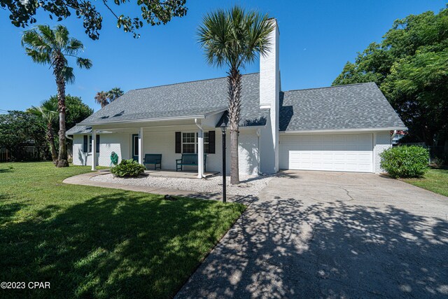 view of front of property with a front lawn, a porch, and a garage