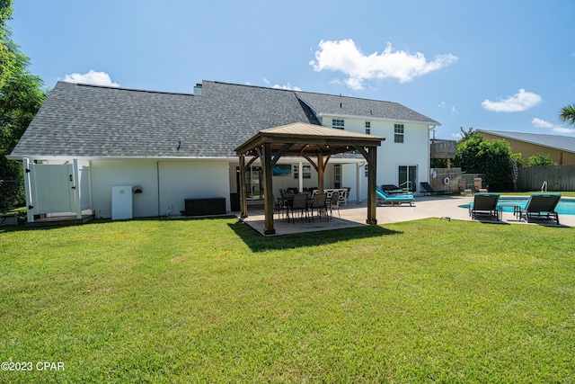 rear view of house with a patio area, a gazebo, a yard, and central AC