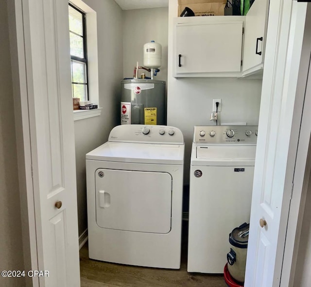 washroom with water heater, dark wood-type flooring, cabinets, and washer and dryer