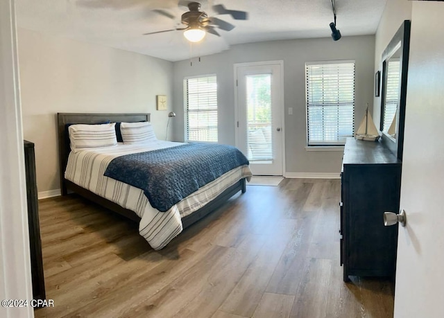 bedroom featuring hardwood / wood-style flooring, ceiling fan, and access to exterior