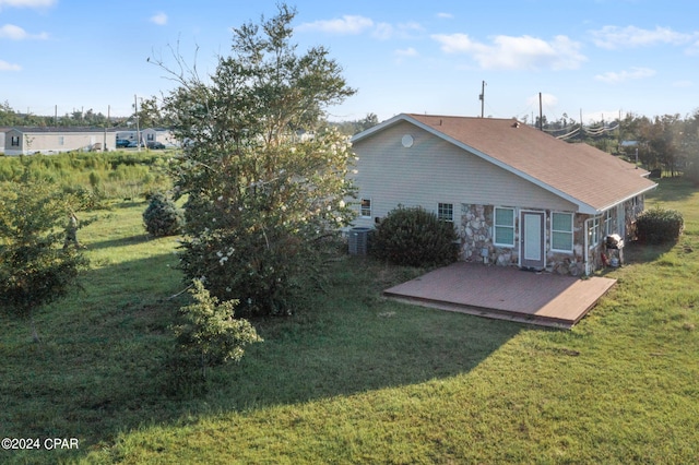 rear view of house with a yard, a deck, and central air condition unit