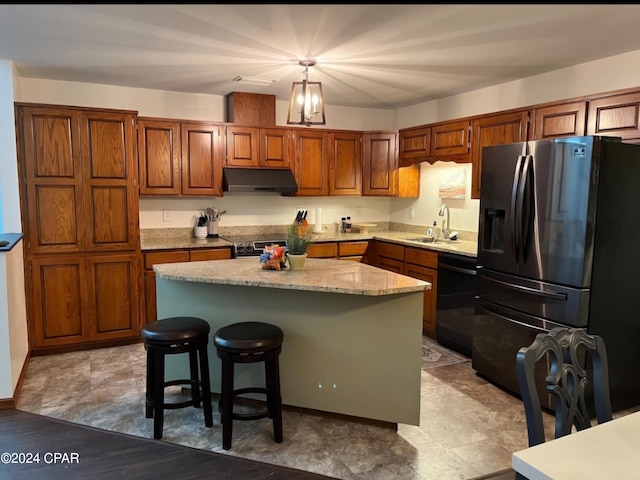 kitchen featuring a breakfast bar area, stainless steel appliances, sink, pendant lighting, and a center island