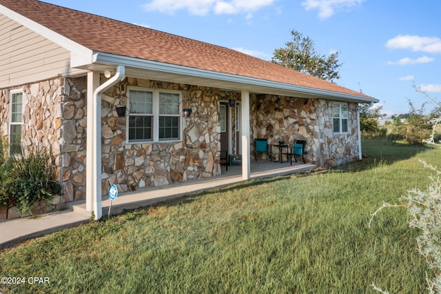 rear view of property featuring a yard and a patio