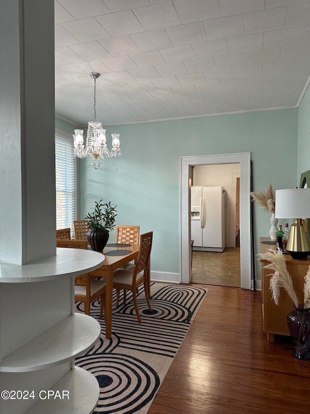 dining area with crown molding, a chandelier, and hardwood / wood-style flooring